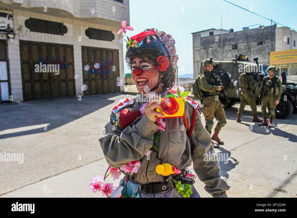 nablus-palestine-03rd-mar-2023-an-israeli-activist-dressed-as-a-clown-plays-in-front-of-a-foot-patrol-of-i...soldiers-in-the-town-of-hawara-south-of-nablus-in-the-occupied-west-bank-credit-sopa-images-limitedalamy-live-news-2P1J32W.jpg
